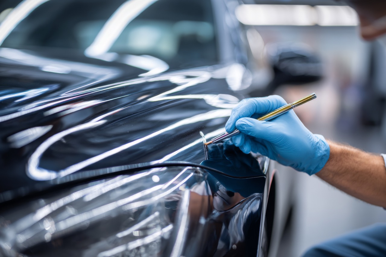 vecteezy_a-man-in-blue-gloves-is-painting-a-car_71102760